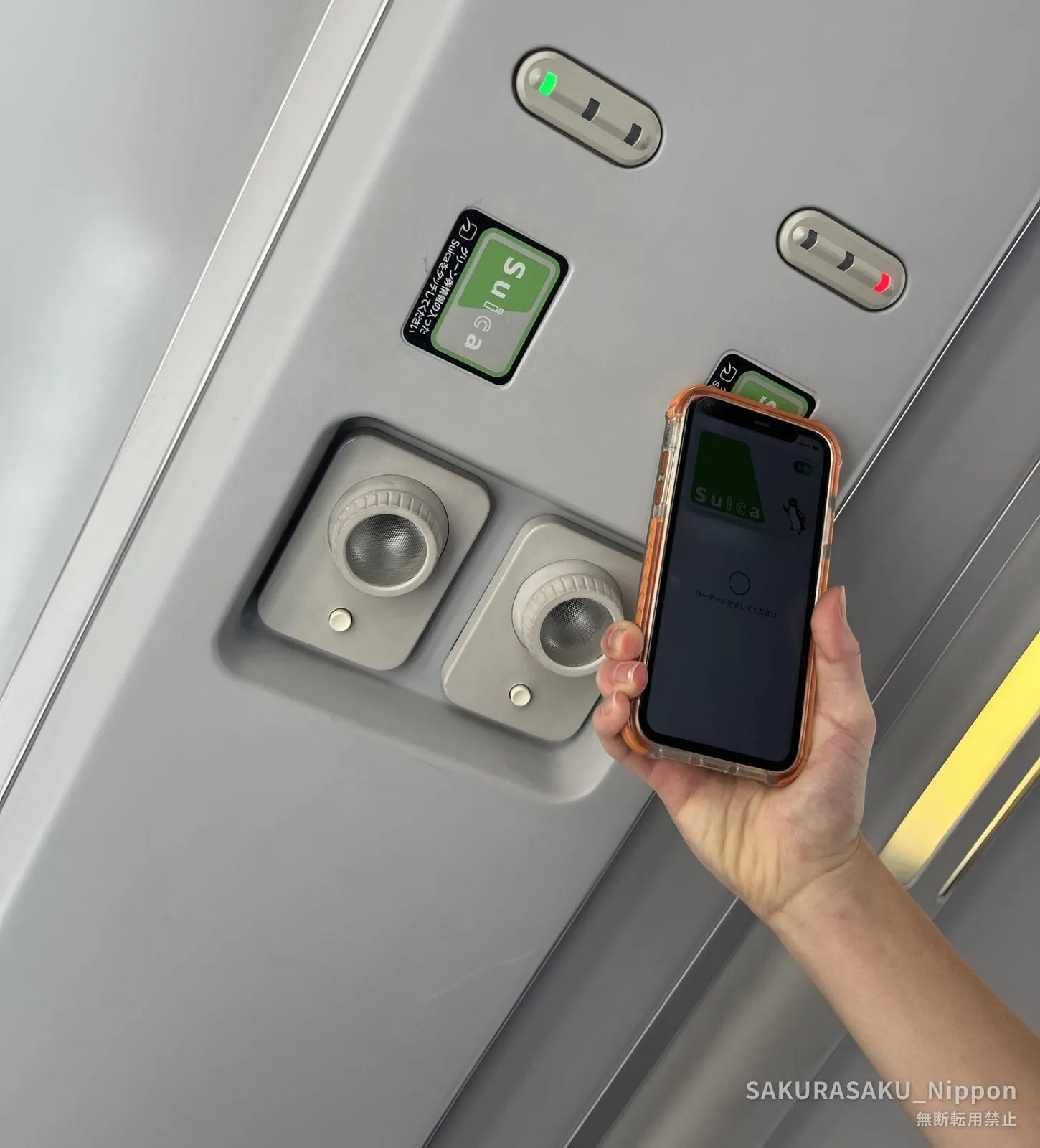 座席の天井にあるカードリーダーに、スマートフォンをかざしているところ