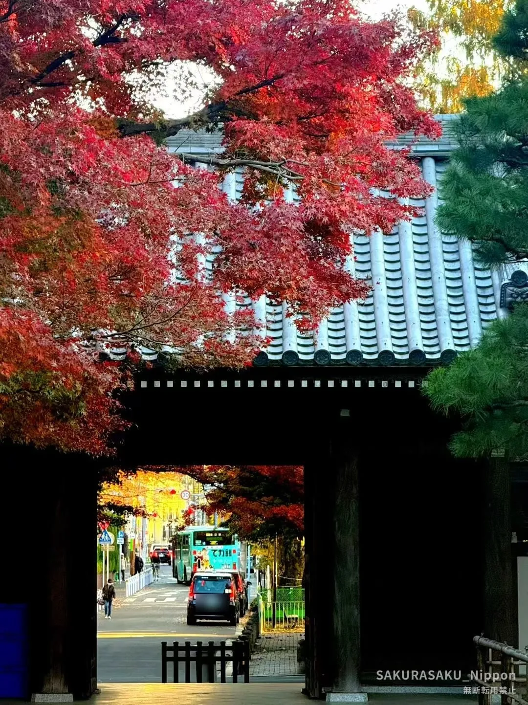 Autumn 2025, looking back from under the gate of Kansen-ji: just outside is an ordinary street with a bus going by