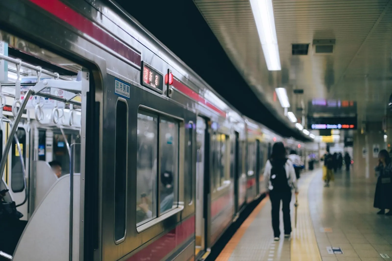 A Keio Line train at a station platform, bound for Shinjuku